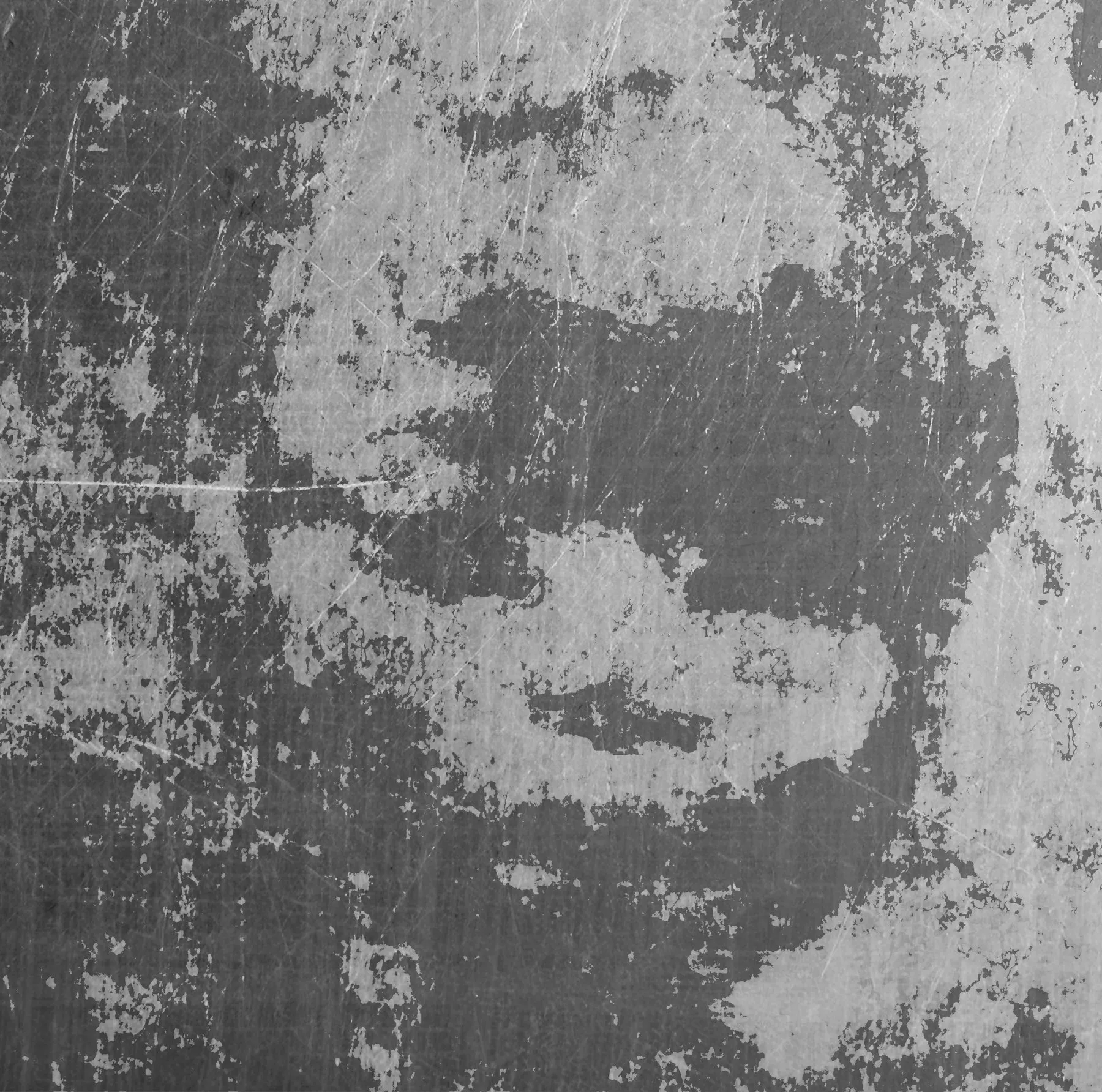 A worn metal surface, scratched and part-stripped, the remaining paint reading as a weathered face.