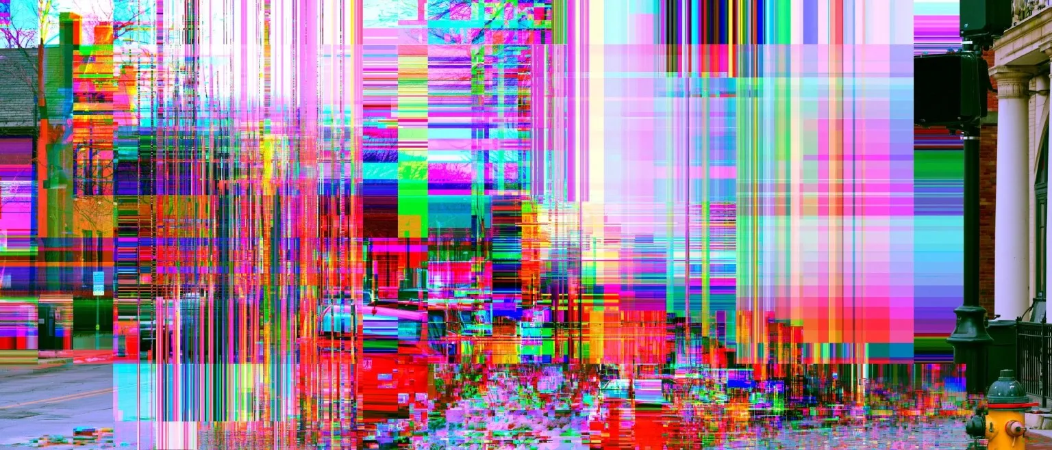 A street scene shattered into blocks of shifted colour, red and cyan channels sheared apart around a fire hydrant.