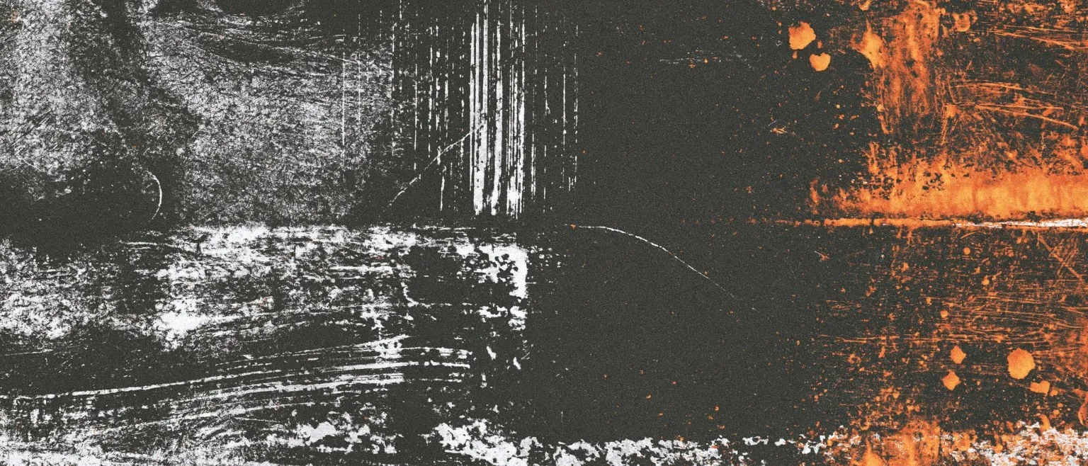 A white scraped band across black, orange bleeding in from the right.