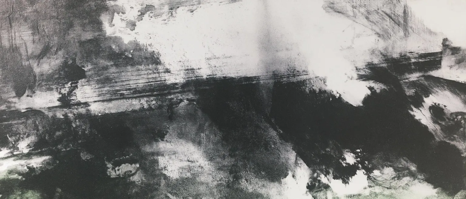 A dark landmass under a pale sky, its edges dissolving.